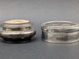 two silver containers sitting next to each other on a table