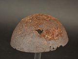 a rusty helmet with a hole in the middle of it