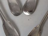 four silver spoons and two silver spoons on a white surface