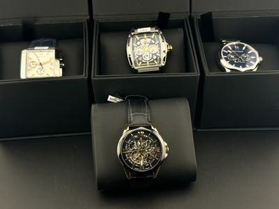 Plusieurs montres se trouvent dans une boîte noire posée sur une table
