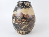 a vase with a painting on it on a white surface