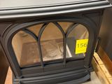 a black stove sitting in a room with a sign on it