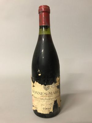 une bouteille de vin rouge posée sur une table blanche