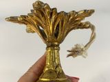 a person holding a gold vase with a red heart on it