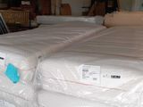 two mattresses stacked on top of each other in a warehouse