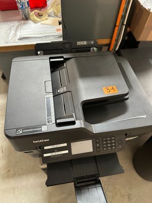 a printer sitting on top of a desk next to a computer