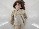 une petite poupée assise sur une surface blanche