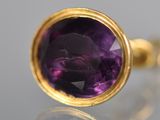 an image of a close up of a ring with a purple stone