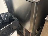 a stainless steel refrigerator in a kitchen next to a trash can