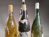 three empty wine bottles sitting next to each other on a table