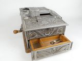 an antique silver metal cash register with a wooden drawer and a pair of scissors
