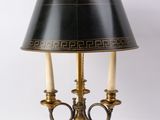 une lampe de table noire et dorée, munie d'un abat-jour noir