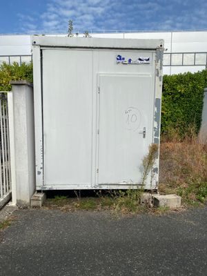 a white toilet sitting in the middle of a parking lot