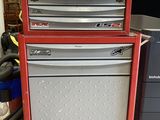 a red tool cabinet with four drawers on top of it