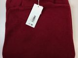 a close up of a red sweater with a tag on it