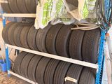 many tires stacked on a rack in a store
