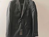 grey suit jacket hanging on a hanger on a white wall