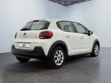 the rear of a white car is parked in a large room