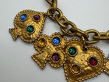 a close up of a gold necklace with colorful stones on it