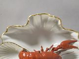 a red lobster sitting in a shell shaped dish