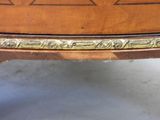 a close up of a wooden table with gold trimming