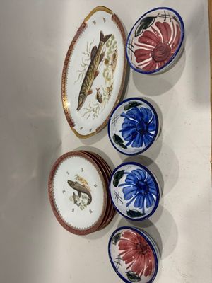 cinq assiettes ornées de poissons et de fleurs, accrochées au mur
