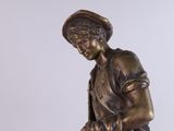 bronze statue of a boy with a dog on a pedestal