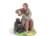figurine représentant un homme assis sur un banc avec une chaussure