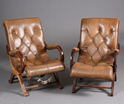 deux fauteuils en cuir marron, avec des pieds et des accoudoirs en bois, sur fond gris