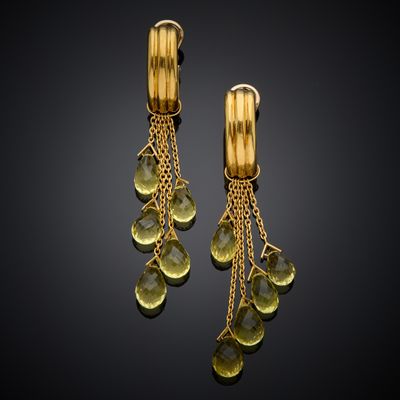 a pair of yellow gold earrings with green stones