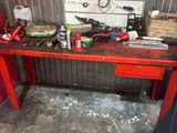 une table rouge sur laquelle sont posés des outils, dans un garage