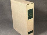 an old book sitting on top of a table next to a gray background