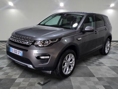 La Land Rover grise est garée dans le garage, sur un sol à damier.