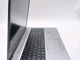 a silver laptop with a black keyboard on a white surface