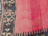 an old rug with a red and black design on it