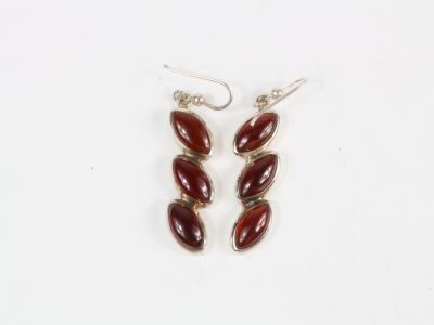 une paire de boucles d'oreilles auxquelles sont suspendues des perles de verre rouges