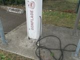 a white gas pump sitting on the side of the road