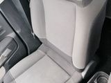 two seats in the back of a car with a cup holder in the center