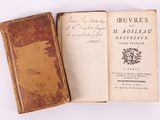 an old book sitting on top of a white table next to a book