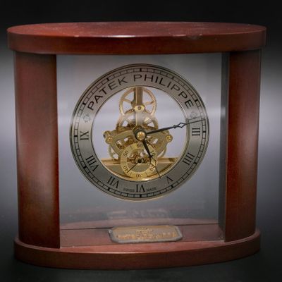 une horloge posée sur une table sur laquelle se trouve une autre horloge