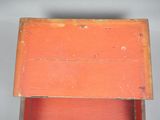 a small wooden box with a red lid on a table