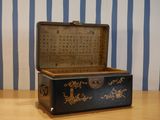 a black and gold chest sitting on a wooden table