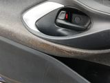 a close up of a car door handle with a red button