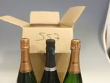 trois bouteilles de vin dans un carton posé sur le comptoir