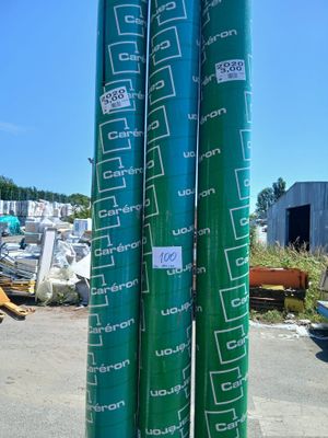 deux rouleaux de bâche verts posés sur le bord de la route