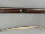 un vieux fusil muni d'une longue crosse en bois et d'une longue crosse en bois