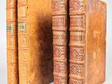 deux vieux livres posés l'un à côté de l'autre sur une surface blanche