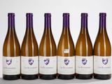 six bouteilles de vin sont alignées sur une surface blanche