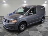 La camionnette grise est garée dans le garage, sur un sol à damier.
