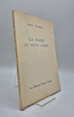 un vieux livre posé sur une table à côté d'un mur blanc